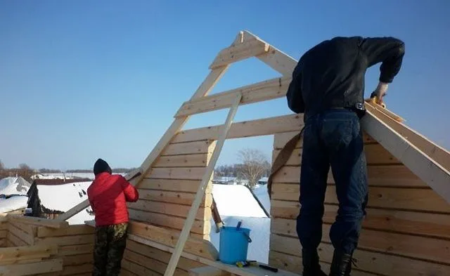 Крайняя пара стропильных ног стала отличным ориентиром для дальнейшего возведения фронтонной стены из бруса.