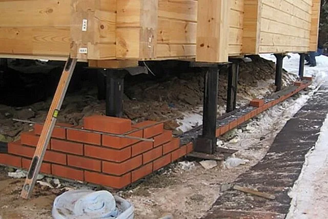 Пространство между грунтом и обвязкой можно закрыть по периметру и утеплить, а иногда – даже найти ему полезное применение