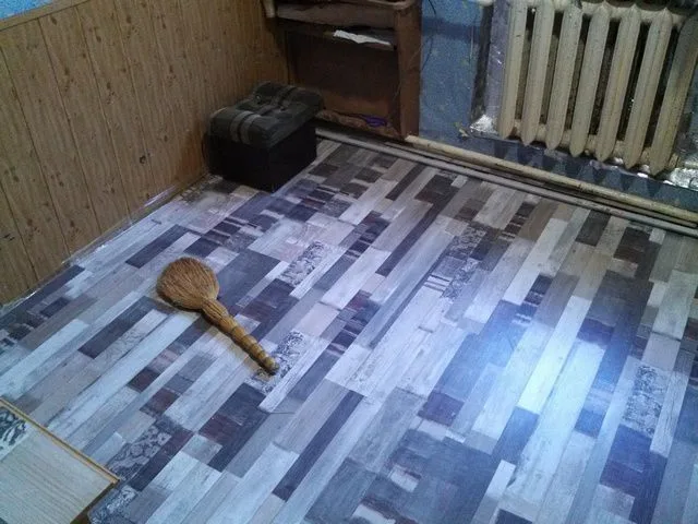 Ламинированное покрытие полностью уложено. Выступающий край полиэтиленовой пленки обрезается ножом вровень с полом