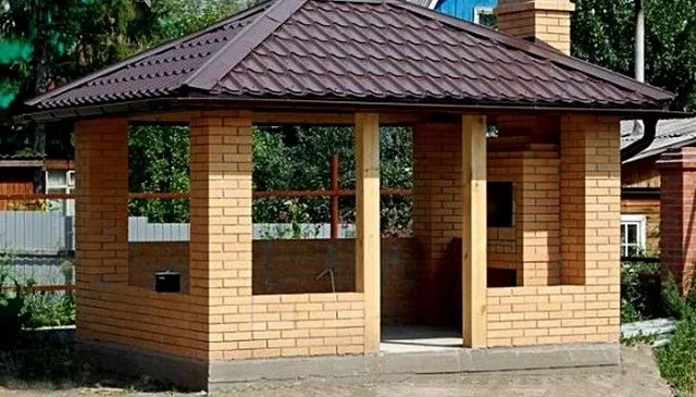 Кирпичная беседка с комплексом барбекю на загородном участке.