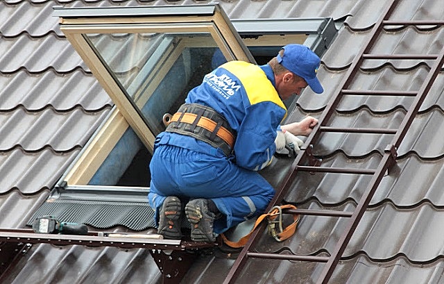 Если лестница надежно зафиксирована на поверхности ската крыши, то закрепиться при работе на высоте вполне можно и за нее.