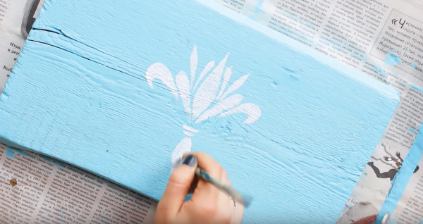 Украсьте будущий поднос рисунком. Трещинки на поверхности замаскируйте пастой с эффектом «металлик». Чтобы рисунок не выглядел слишком ярко его необходимо слегка затереть наждачной бумагой. Сверху поверхность покройте акриловым лаком