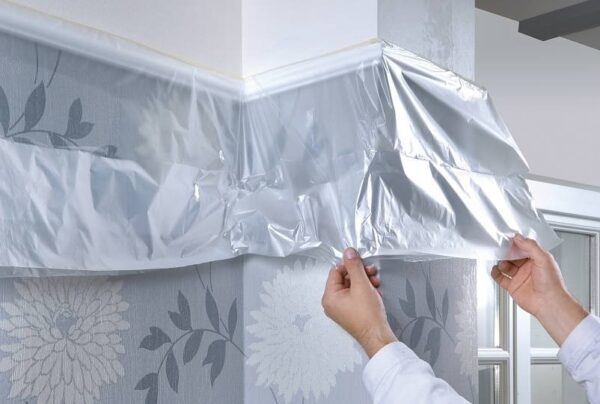 Перед нанесением краски на потолок защищаем стены, пол и мебель от брызг и капель
